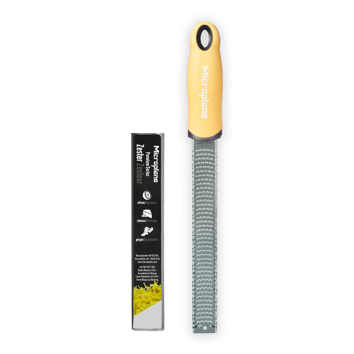 Zester with yellow handle and black label on a white background